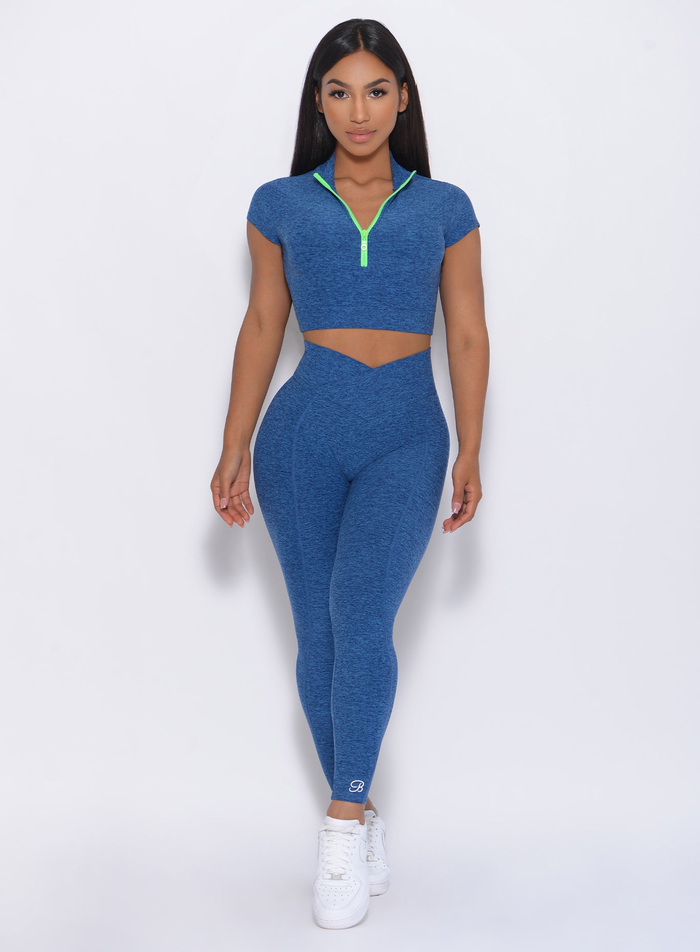 Model facing forward wearing our Brazilian contour leggings in ocean color and a matching bra 