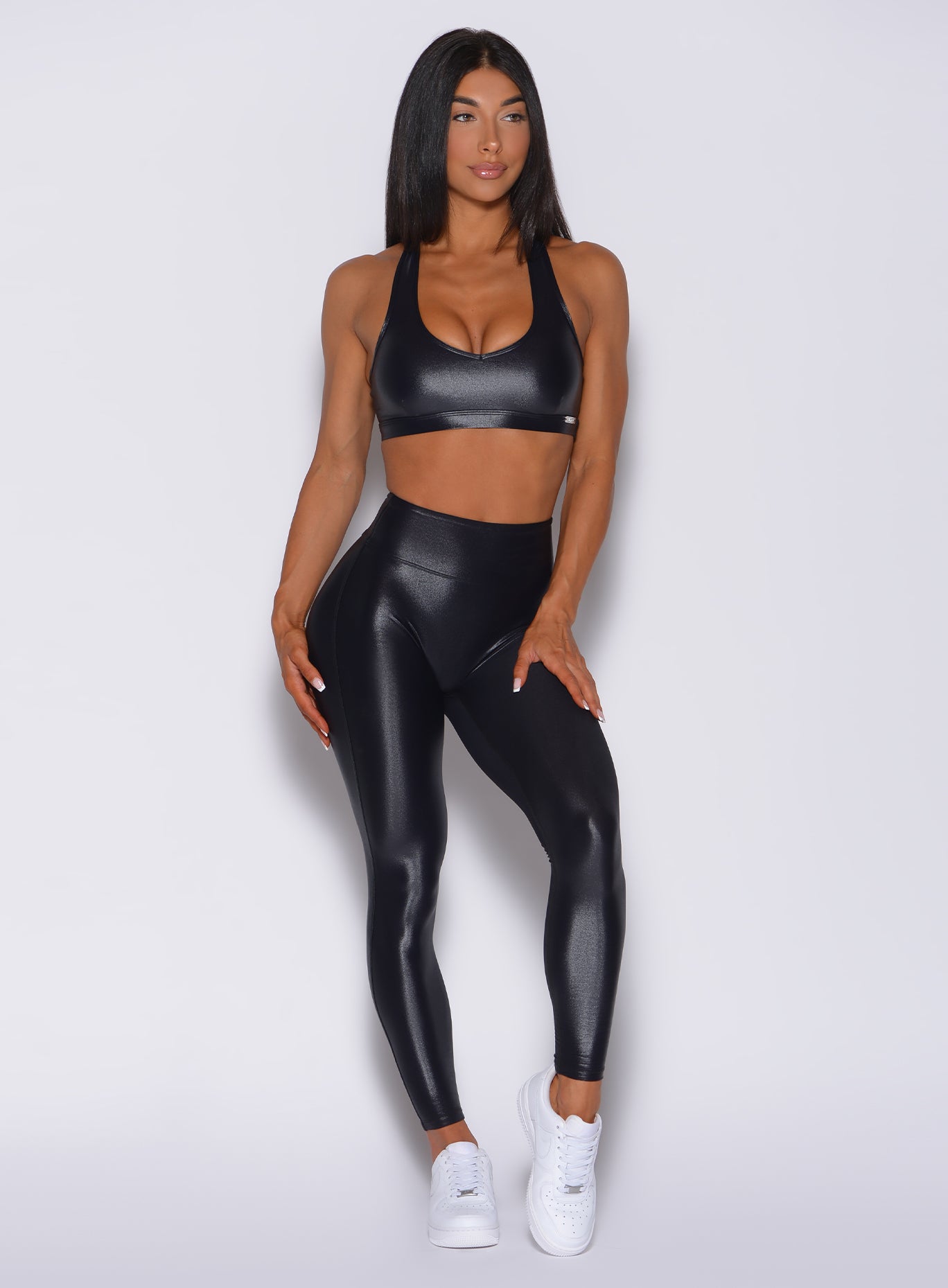 Front profile view of a model in our gloss black leggings and a matching bra 