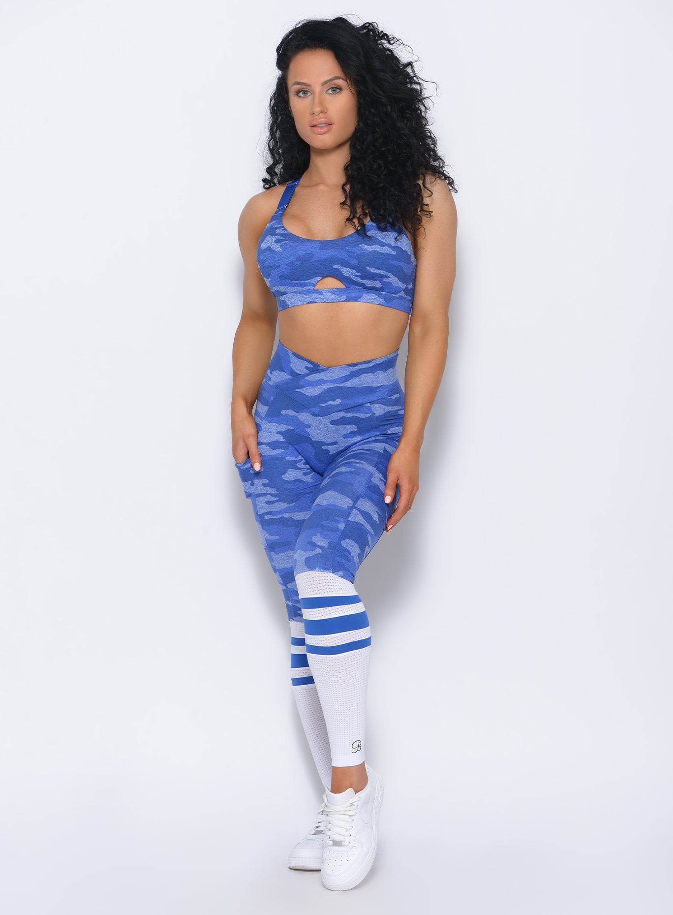 Front profile view of the model wearing our contour sock leggings in blue camo and a matching bra