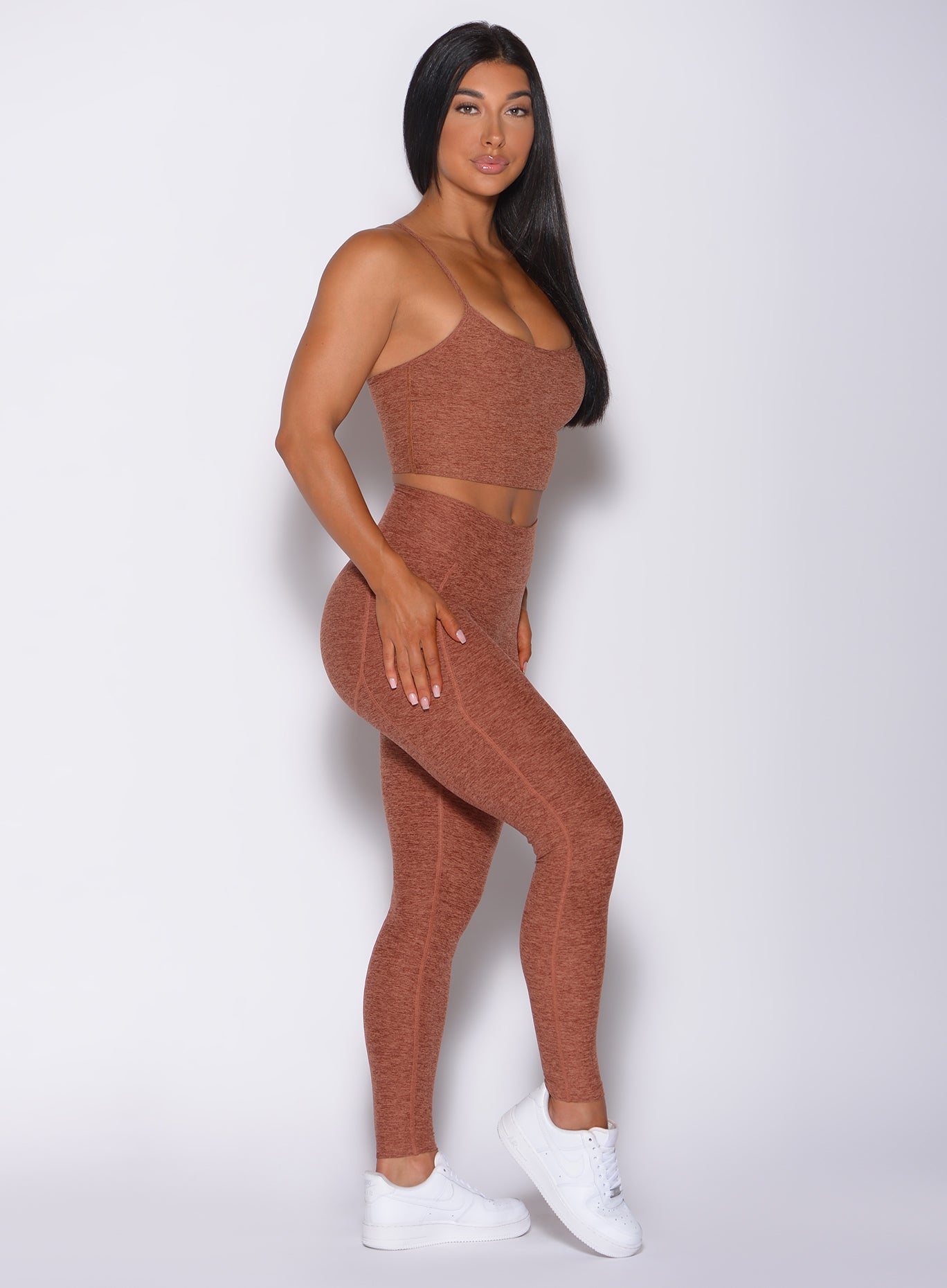 Right side profile view of a model wearing our uplift pocket leggings in spiced chai color and a matching bra